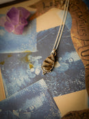 Magie Ancestrale - Collier en fossile d'ammonite et argent, étoile du Nord au dos